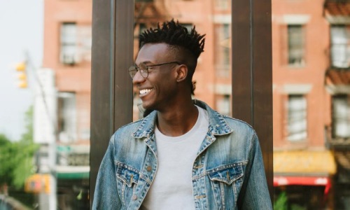 a man smiling and standing outside