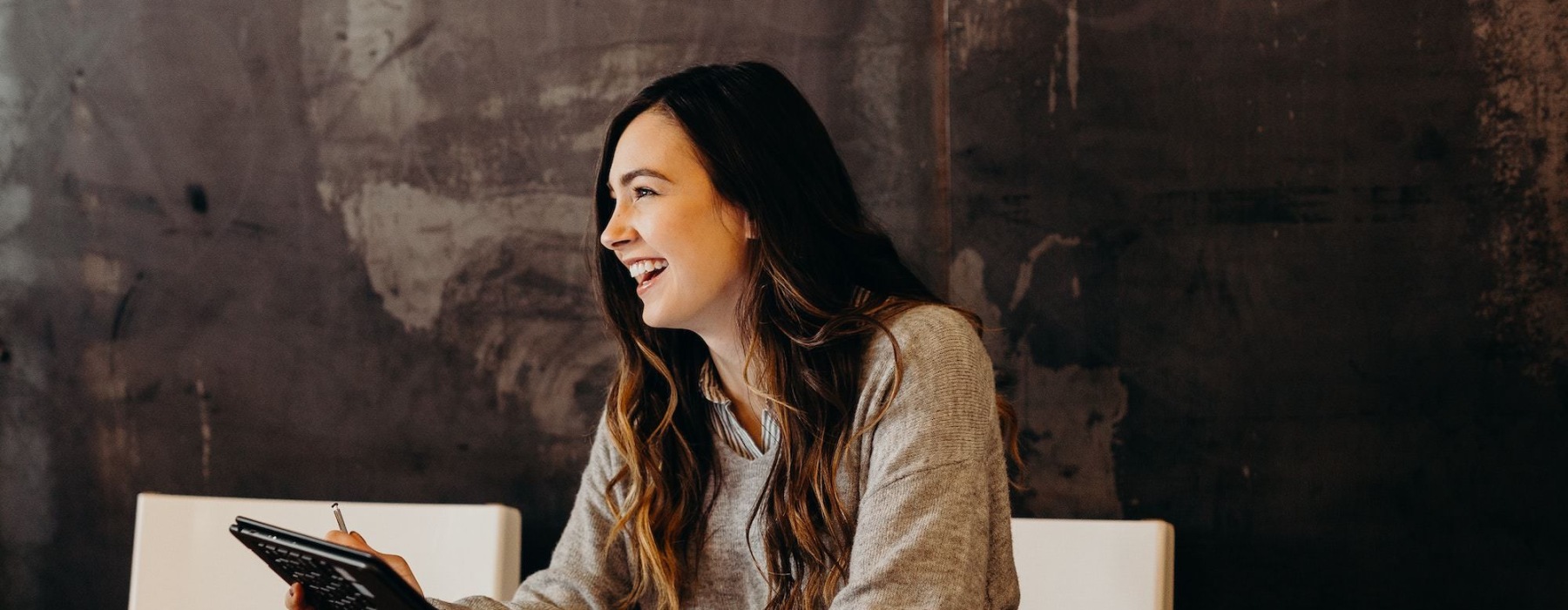 a woman holding a tablet smiling